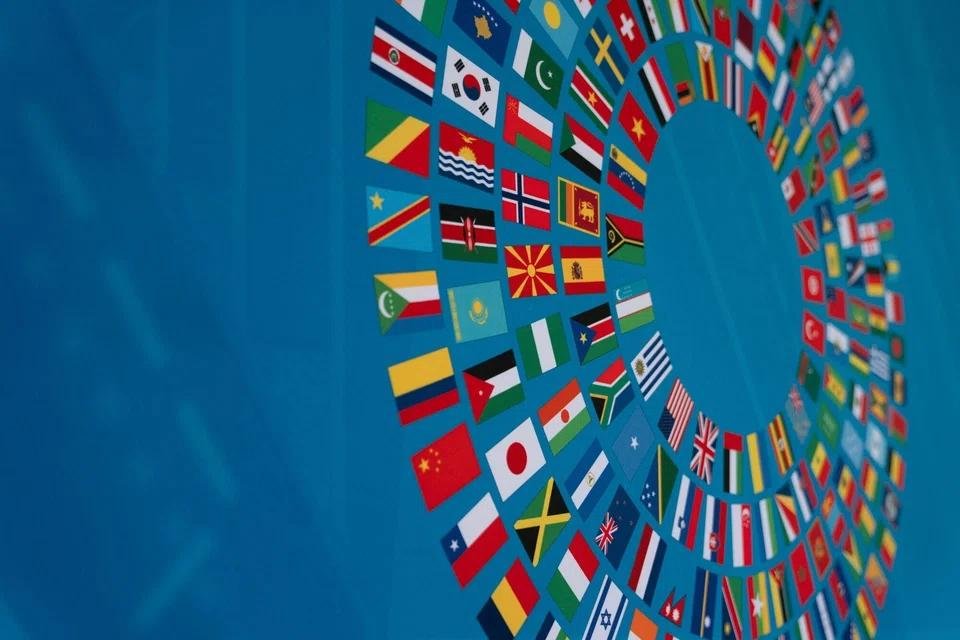 A curved display of national flags at an international conference venue