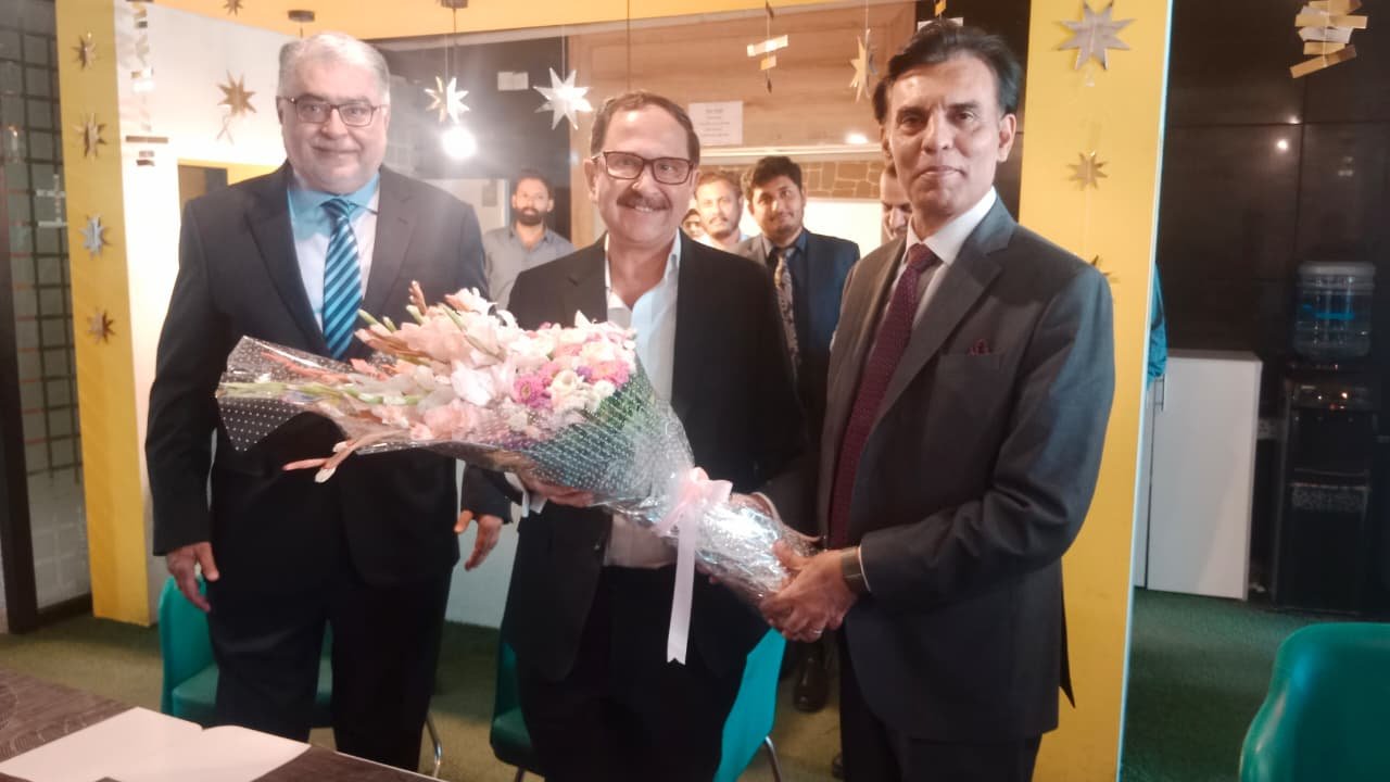 Bilal Anwar being presented with a bouquet of flowers by colleagues