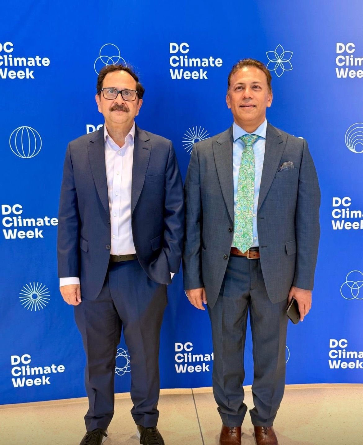 Bilal Anwar with a colleague in front of the DC Climate Week backdrop