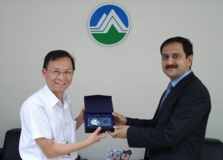 Bilal Anwar exchanging a commemorative plaque with a host official during his diplomatic service