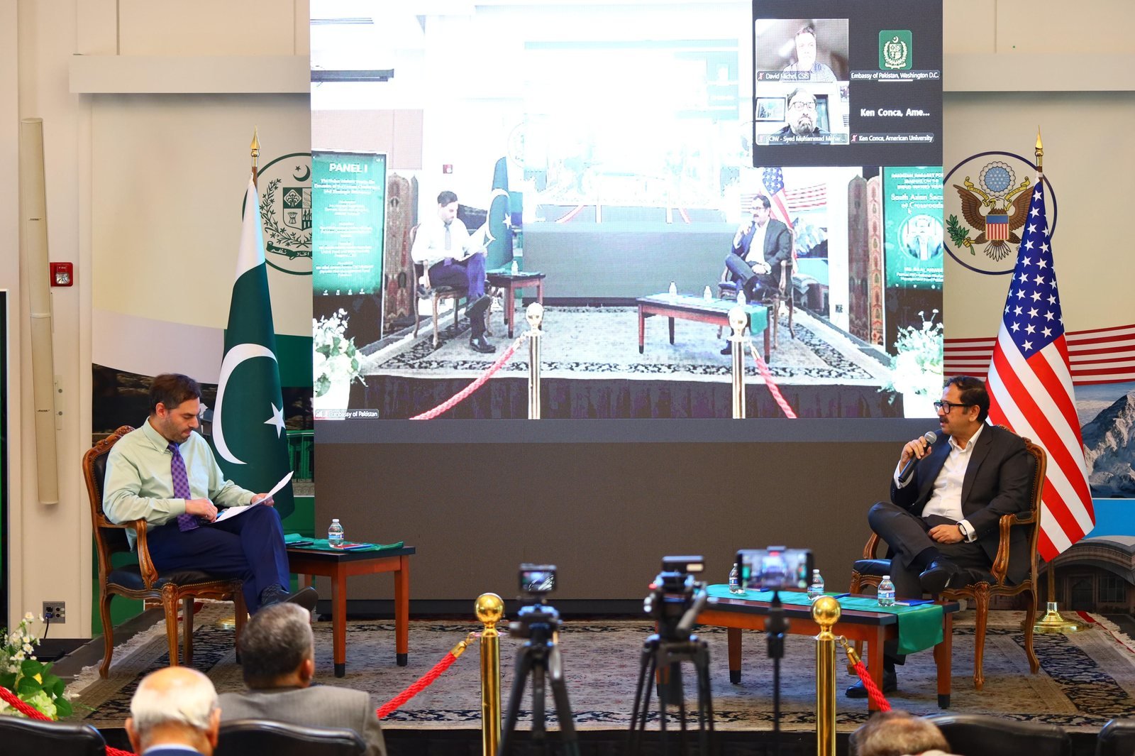 The Indus Waters Treaty panel in session at the Embassy of Pakistan in Washington, D.C., the discussion relayed on the screen behind with the participants joining by video