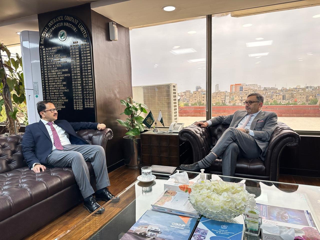 Bilal Anwar in a meeting at the National Insurance Company Limited office, the Karachi skyline behind