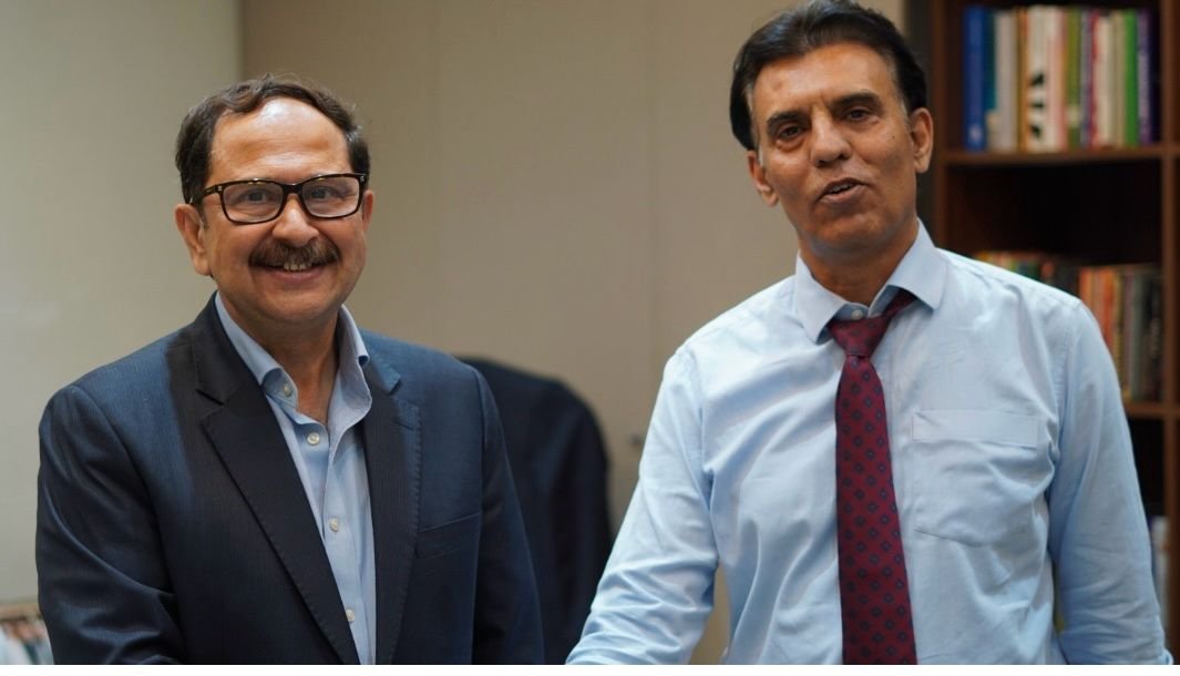 Bilal Anwar with a colleague in an office, a bookshelf behind them