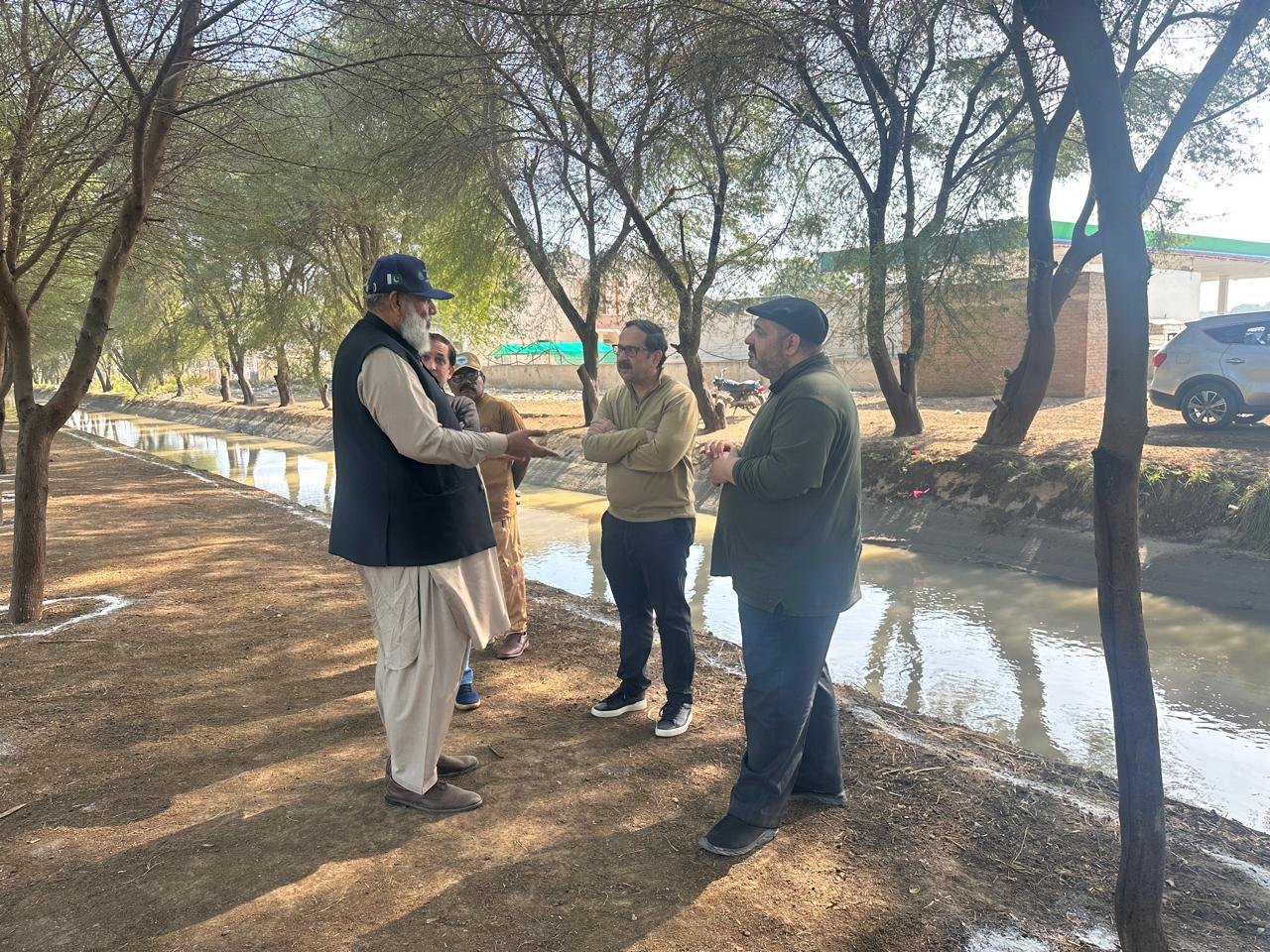 Bilal Anwar and colleagues in conversation on the canal bank at the Tando Allahyar plantation site