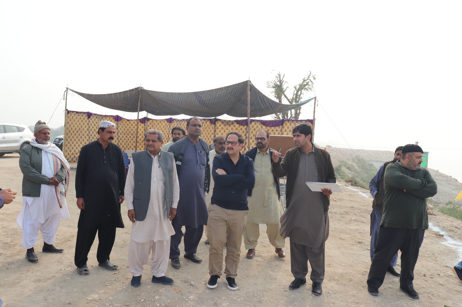 Bilal Anwar and a team gathered on a riverbank beside a briefing tent