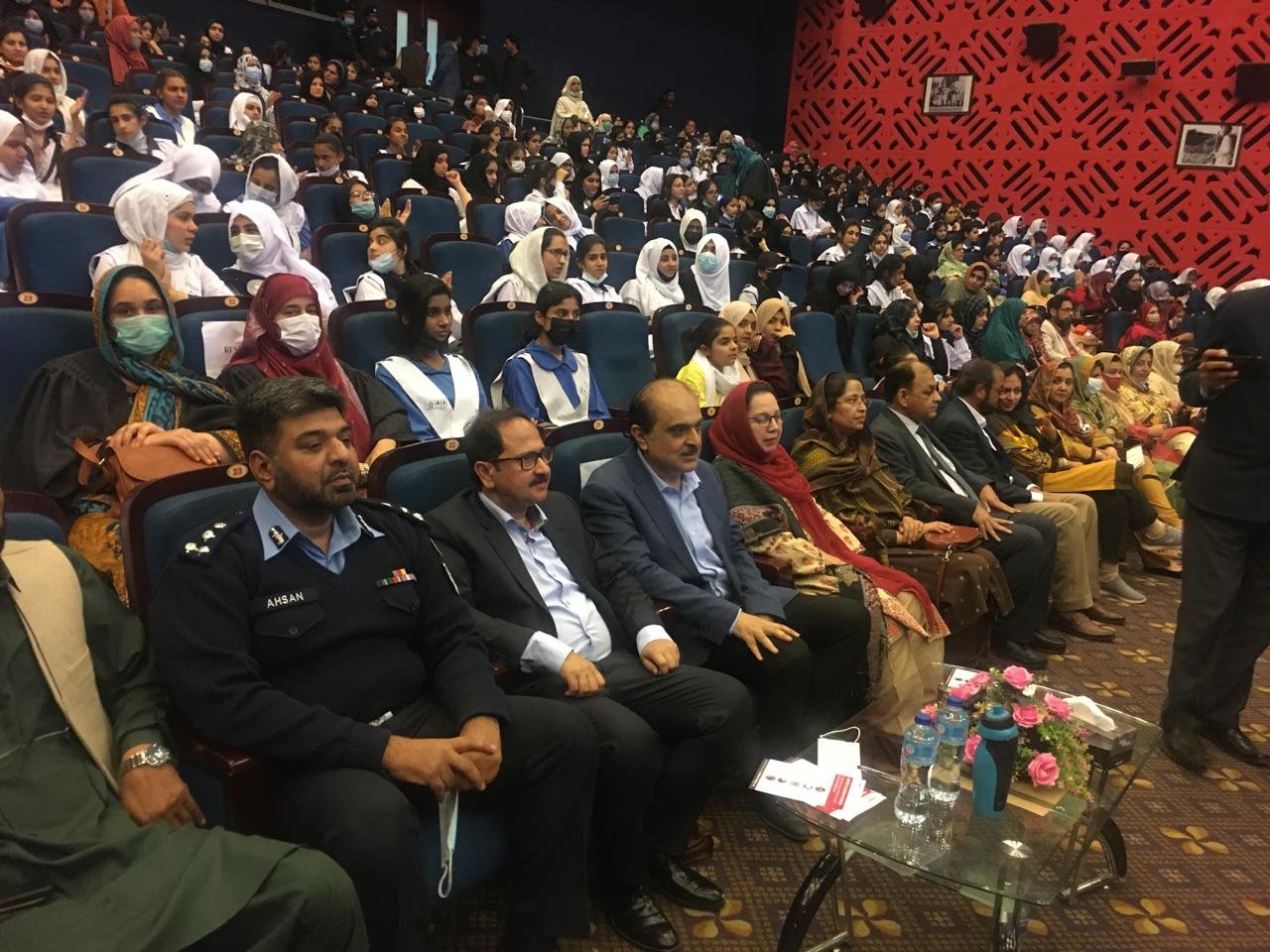 A packed school auditorium of students, with officials and guests seated in the front row