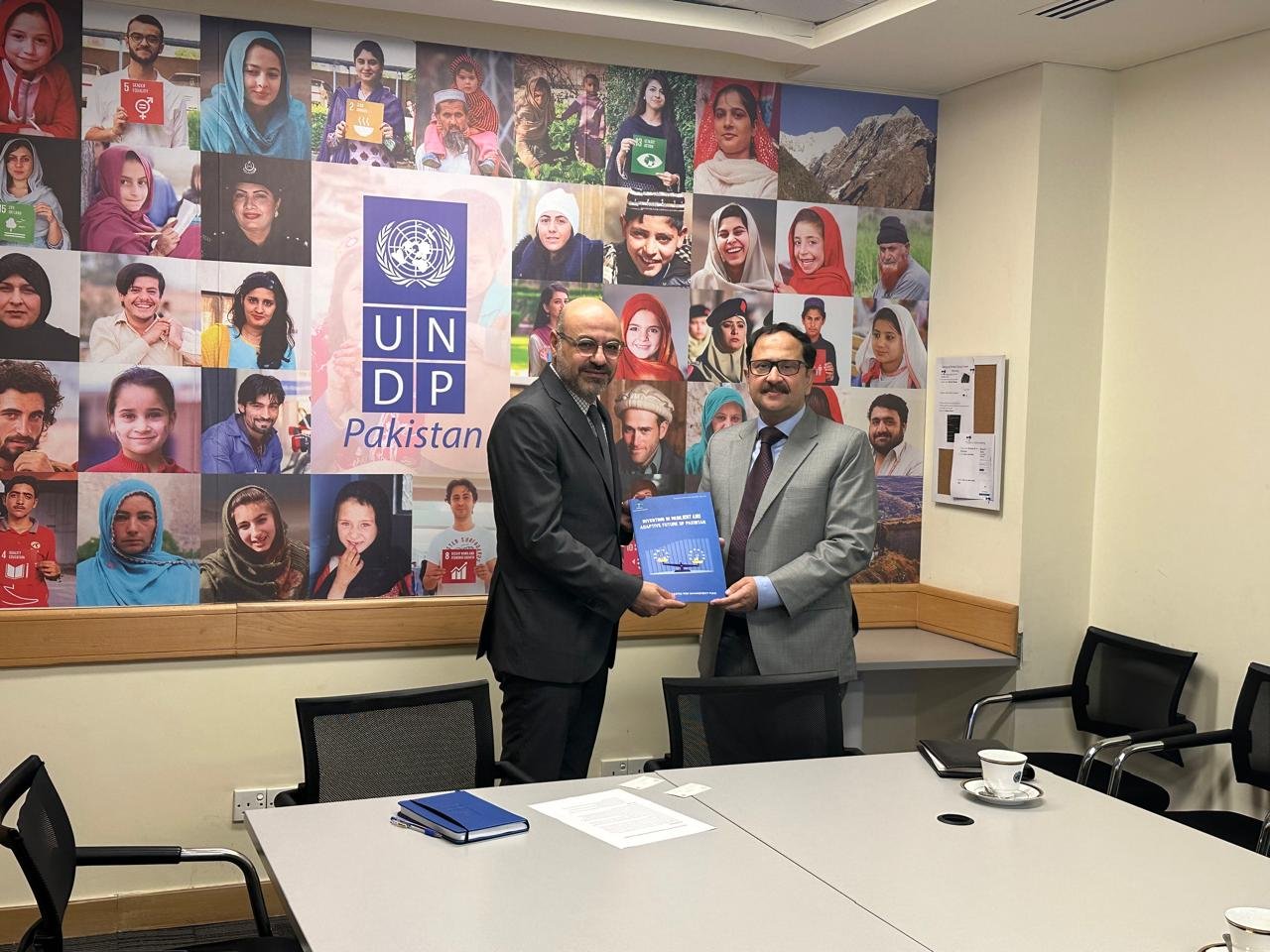 Bilal Anwar handing over the report Investing in a Resilient and Adaptive Future of Pakistan at the UNDP Pakistan office