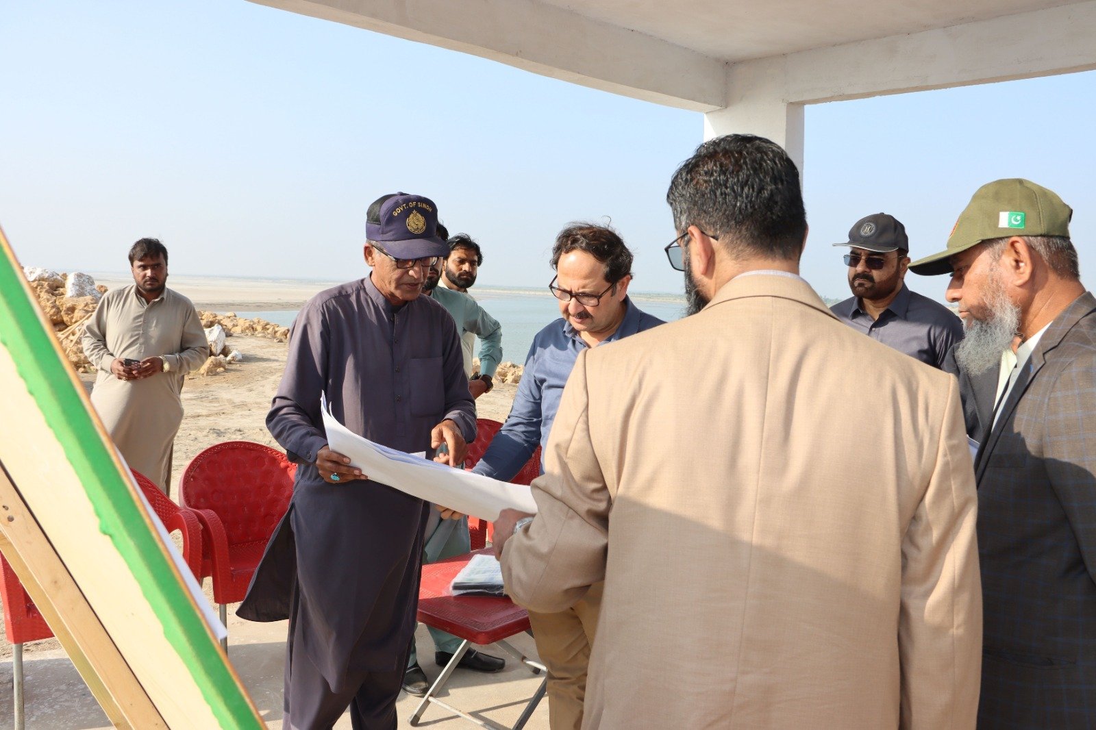 Bilal Anwar reviewing site drawings with engineers and officials at Sujawal, Sindh